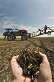 Soil with sprayer being used for liquid fertilizer application in the background