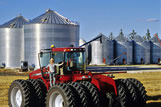 Girl on tractor with grain bins in the background